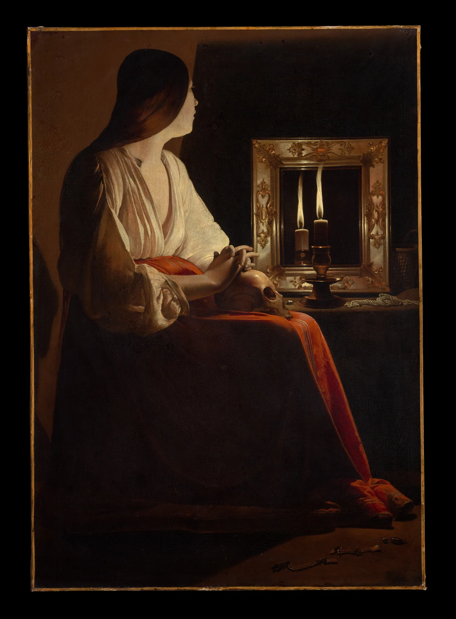Georges de La Tour'un tablosunda bir kadın, önünde yanan bir mum ve kucağında bir kafatasıyla oturuyor; odanın geri kalanı karanlık.